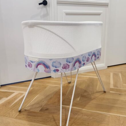 Snoo bassinet with rainbow-themed custom wrap on hardwood floor