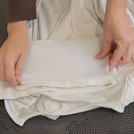 Close-up of hands applying soft Velcro strip to worn Snoo Sack band