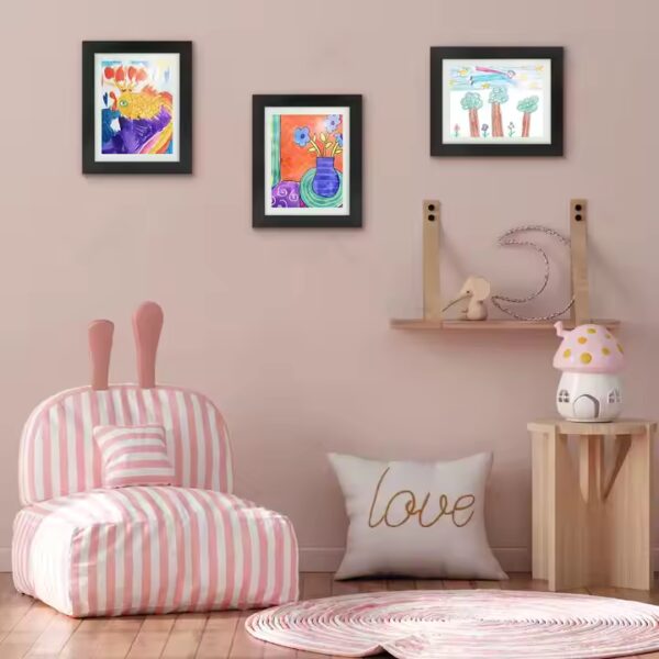 Black A4 frame with kids artwork on wall, horizontal view