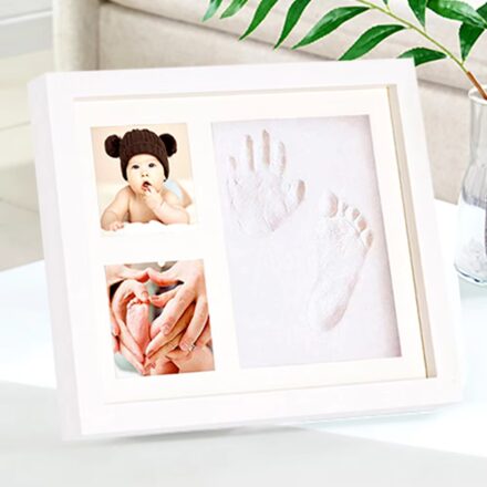White photo frame kit with two photo slots and central clay impression area, styled for baby handprints and footprints