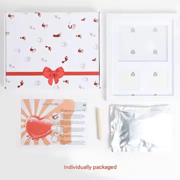 All components of clay baby handprint and footprint photo frame kit laid out, including frame, clay pack, roller, and alphabet stamps