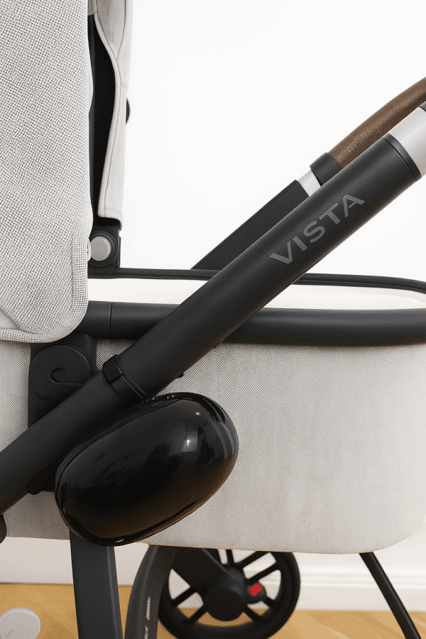 Close-up of electric pram rocker attached to black pram frame with grey fabric and brown handle, showing USB charging port and secure mount