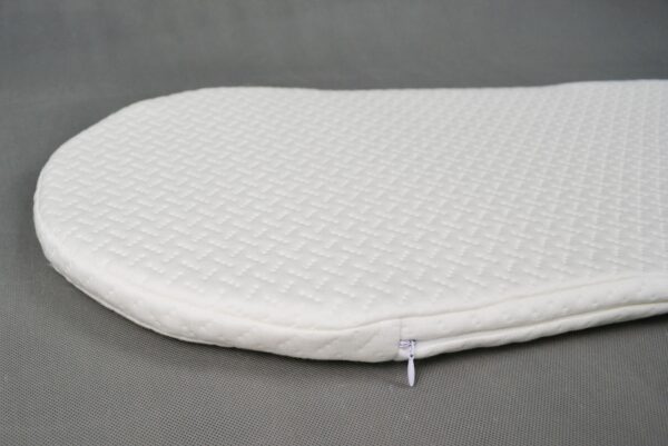 Close-up of Snoo bassinet mattress showing corner zip and textured organic cotton cover.