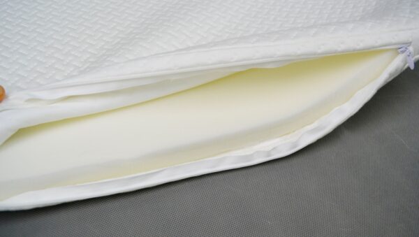 Close-up view of Snoo-compatible bassinet mattress with zip-off quilted cover partially open to show internal foam core.